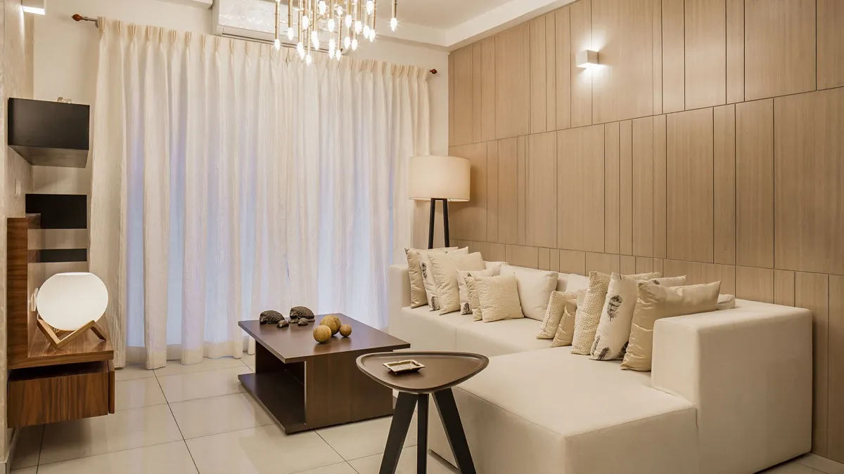 Living room with a cream sectional sofa, floor lamp and light timber wall panelling